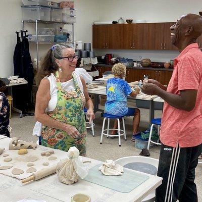 A teacher and student enjoy discussing ceramics techniques