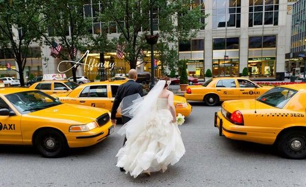 Bride and groom brave the New York City cab traffic to get their photograph taken in the median on Park Ave after their wedding.