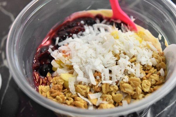 Protein yogurt with fresh fruit, granola and shredded coconut.